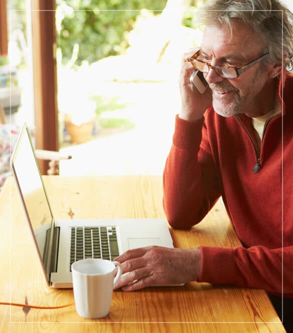 man on phone looking at computer